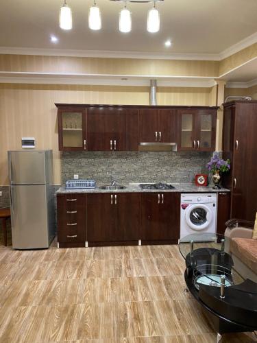 a kitchen with wooden cabinets and a washer and dryer at House Abel in Tsaghkadzor