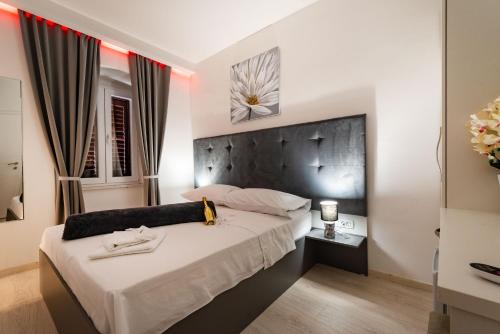a bedroom with a bed with a black headboard at Luxury rooms Zadar old town in Zadar