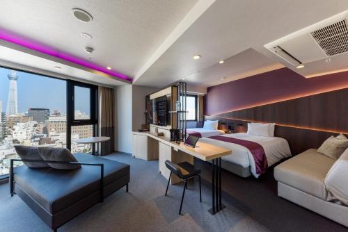 a hotel room with a bed and a desk at Henn na Hotel Premier Tokyo Asakusa Tawaramachi in Tokyo