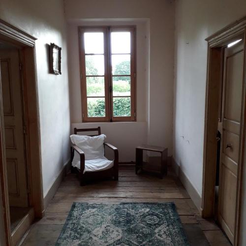 une pièce vide avec une chaise et une fenêtre dans l'établissement Elegant and Spacious Maison de Maitre Ideal for Group Bookings, à Samadet