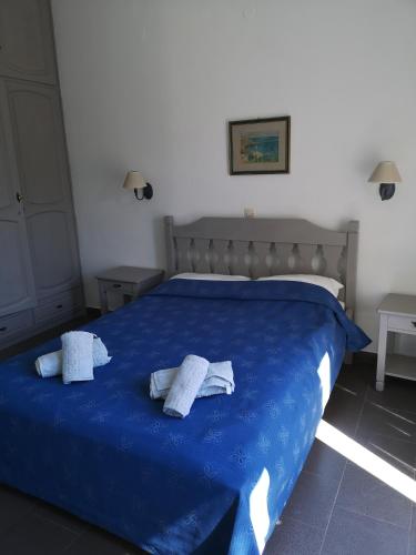 a bedroom with a blue bed with towels on it at Villa Melina Hotel in Kalymnos
