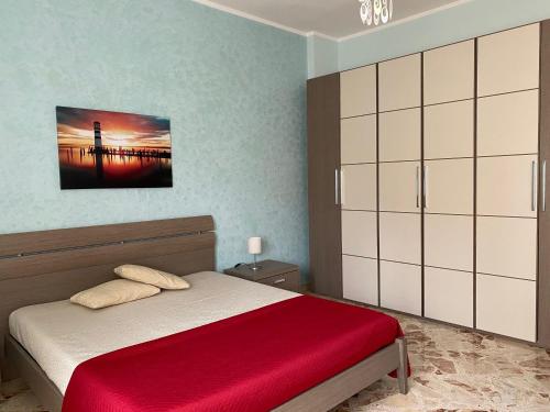 1 dormitorio con 1 cama con manta roja en Relax in Taranto, en Taranto