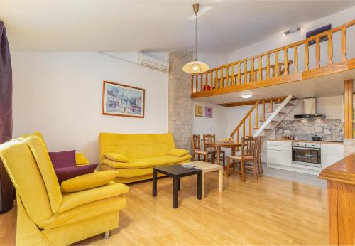 a living room with a yellow couch and a table at Apartments Josipovic in Fažana