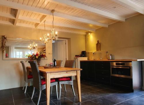 a kitchen with a wooden table and chairs at Chapeau ! in Garderen