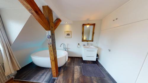 une salle de bain avec une baignoire blanche et un lavabo dans l'établissement 145m² city center 4 bedrooms view of the Cathedral, à Strasbourg