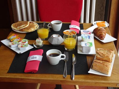 a breakfast table with breakfast foods and coffee and orange juice at Hôtel Ambroise in Uzerche