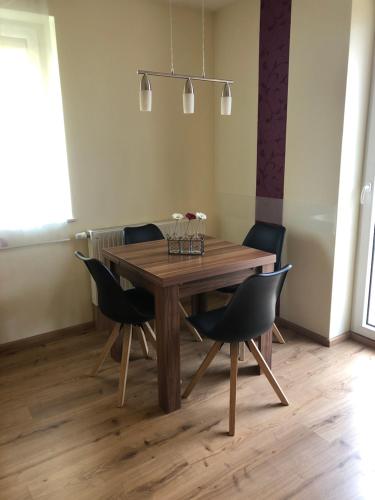 a wooden dining room table with black chairs at Ferienwohnung Winkler in Rothenburg ob der Tauber