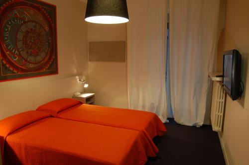 a bedroom with an orange bed and a television at Residence Pian della Nave in Milan