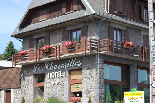 a building with wooden balconies on the side of it at Hôtel Les Charmilles in Besse-et-Saint-Anastaise