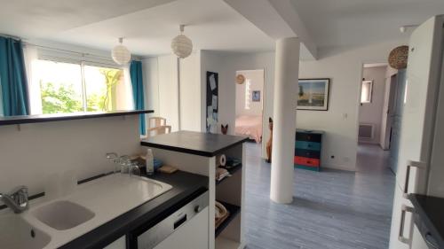 a kitchen with a sink and a room with a bed at Bambou entre Mer et Montagnes in Châteauneuf