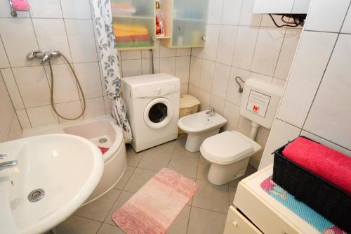 uma casa de banho branca com um lavatório e um WC em Lungo Mare em Pula