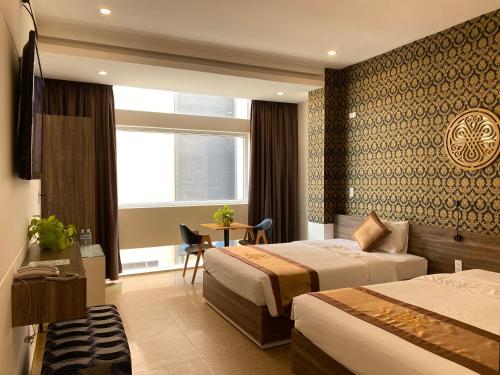a hotel room with two beds and a window at Nice Hue Hotel in Hue