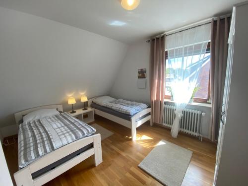 a bedroom with a bed and a window at Gemütliche Ferienwohnung Nesco mit eingezäunten Garten in Aurich