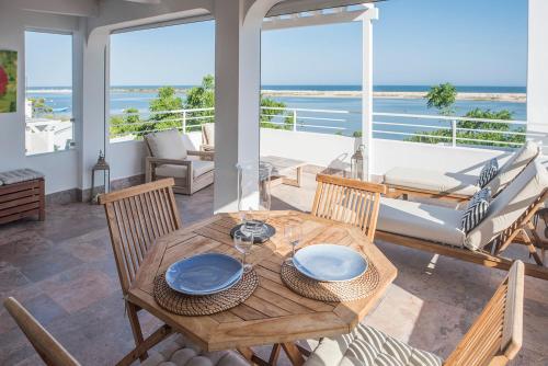 a dining room with a table and chairs and the ocean at Casa Castor, Fábrica, Cacela Velha. in Vila Nova de Cacela