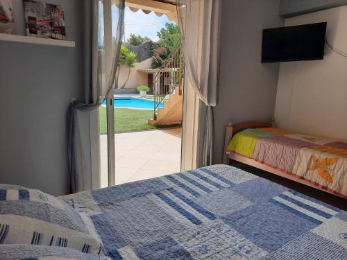 une chambre avec un lit et une vue sur une piscine dans l'établissement Villa Madysan climatisée St Aygulf, piscine privée, 900m de la mer, à Saint-Aygulf