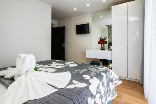 a bedroom with a bed with a gray and white comforter at Skalinada Sea View in Lokva Rogoznica