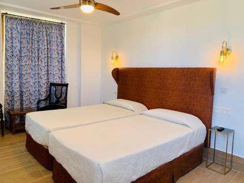 a bedroom with a large bed and a window at Hotel Don Miguel in Ronda