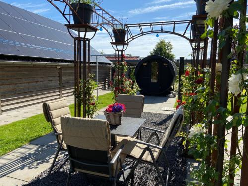 a patio with a table and chairs and flowers at Slapen an de Veenvaart in Nieuw-Amsterdam