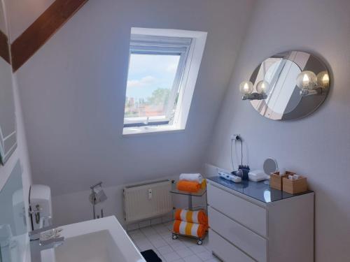 ein Bad mit einem Waschbecken und einem Wandspiegel in der Unterkunft Apartments Suzy in Leipzig