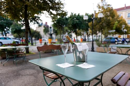 a blue table with a bottle of wine and two glasses at Best Western Hôtel de France in Bourg-en-Bresse