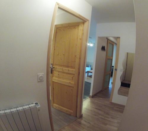 - une porte en bois dans une chambre avec couloir dans l'établissement La Gentiane, à Le Mont-Dore