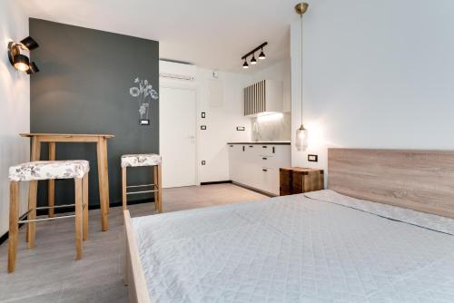 a bedroom with a large bed and a kitchen at Black & White Apartments in Rijeka