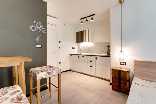 a kitchen with white cabinets and a table and stool at Black & White Apartments in Rijeka