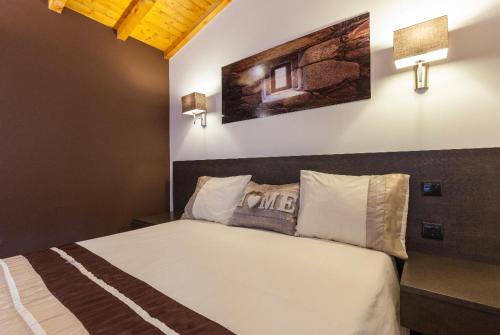 a bedroom with a bed with two pillows on it at Casa da Fonte Gerês in Campo do Gerês