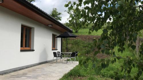a patio with a table and chairs and an umbrella at Apartmán NA KOPCI Krucemburk in Křížová