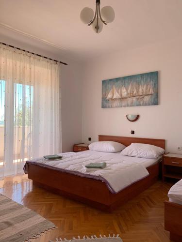 1 dormitorio con 1 cama grande en una habitación en Apartmans and rooms ''Slavica'', en Novalja