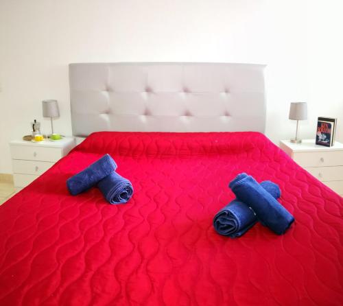 2 cuscini blu su un letto rosso in una camera da letto di Eldorado Casa Gi a Playa de las Americas