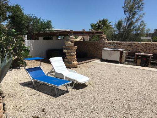 2 Liegestühle, ein Tisch und ein Kamin in der Unterkunft Villa Respiro in Lampedusa