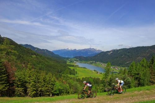 two people riding bikes on a hill overlooking a valley at Ferienhaus Nickl in Weissbriach