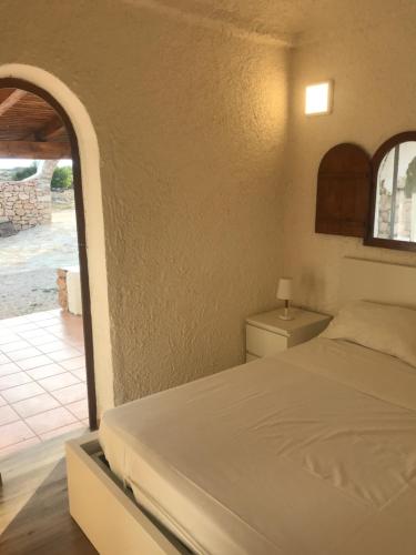 Schlafzimmer mit einem Bett und Blick auf einen Innenhof in der Unterkunft Villa Respiro in Lampedusa