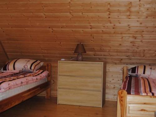 a bedroom with two beds and a lamp on a dresser at Domek w Bartoszymlesie in Stara Kiszewa