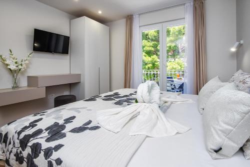 a bedroom with a bed and a tv and a window at Skalinada Sea View in Lokva Rogoznica
