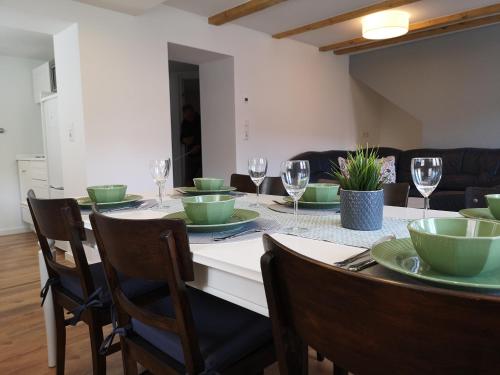 a dining room table with green plates and wine glasses at Ferienwohnung Telemann Stadtmitte in Eisenach