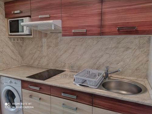 a kitchen with a sink and a washing machine at Mira Apartman in Keszthely