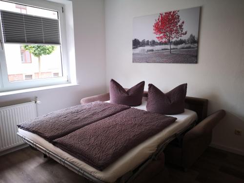 a bedroom with a bed with purple pillows and a tree at Ferienwohnung am Wasserturm in Zwenkau