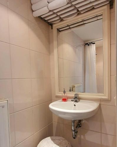 a bathroom with a sink and a mirror at Chapeau ! in Garderen