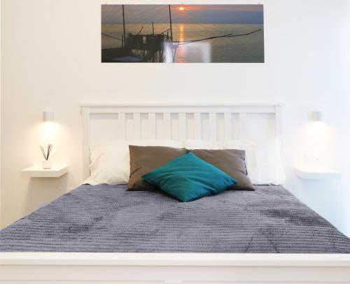 Una cama con una almohada azul encima. en B&B Battisti59, en Vieste
