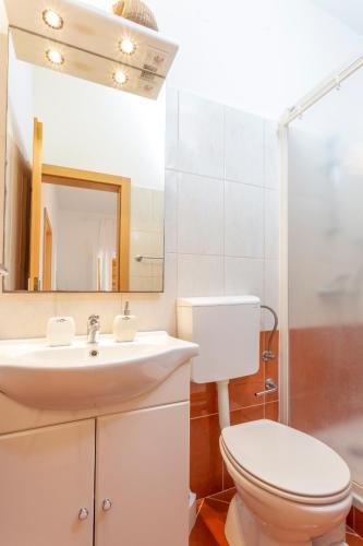 a bathroom with a sink and a toilet and a mirror at Historic center Hvar town- a few steps from the main square in Hvar