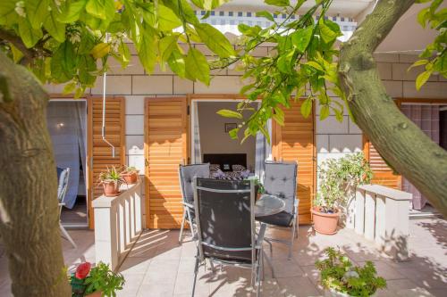 a patio with chairs and a table under a tree at Historic center Hvar town- a few steps from the main square in Hvar