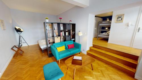 a living room with a blue chair and a table at Loft des Arcades *** – City center in Strasbourg