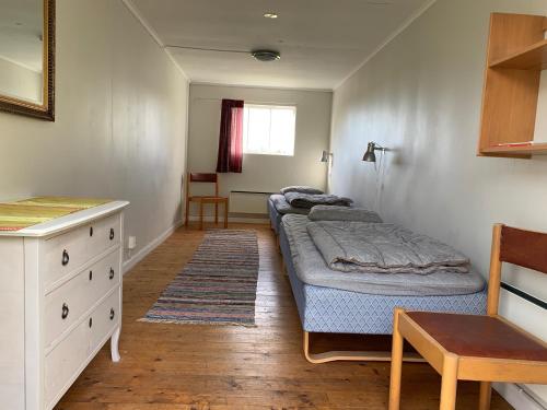 a bedroom with two beds and a desk and a table at Asa Vandrarhem in Lammhult