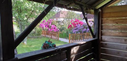 a window view of a garden with pink flowers at Gîtes Les Grandes Voies - Clé Vacances in Le Ménil