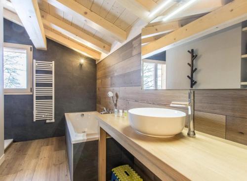 ein Badezimmer mit einem großen weißen Waschbecken auf der Theke in der Unterkunft Les Ours de Combloux in Combloux