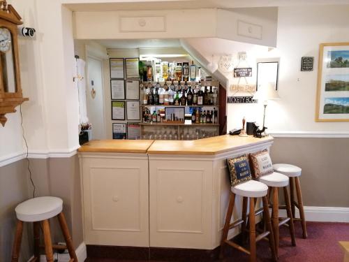 a kitchen with a bar with stools around it at Blue Waters Lodge in Paignton