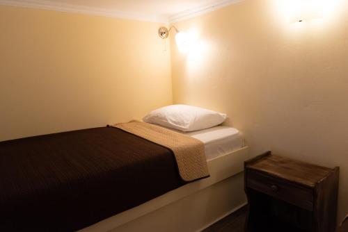 a small bedroom with a bed and a night stand at Evdokia's Apartments and Rooms in Neos Marmaras