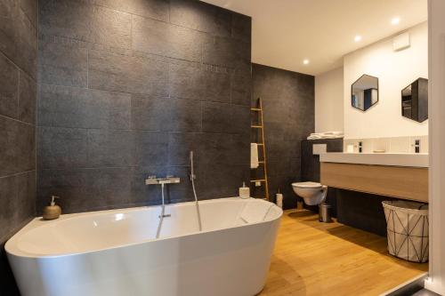 La salle de bains est pourvue d'une baignoire et de toilettes. dans l'établissement La Suite - Honfleur, à Honfleur